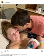 Amy Schumer shares a cosy snap of herself cuddled up with sleeping newborn son Gene Attell...