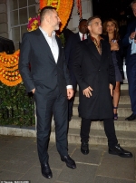 Robbie Williams looks sharp in a black coat and leopard-print shirt as hits the town with pals David Walliams