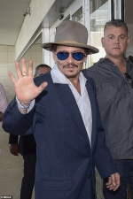 Johnny Depp cuts a dapper figure in navy suit and shades as he greets fans and signs