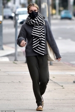 Emma Roberts bundles up with a large scarf and protective face mask