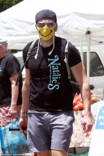 Joel McHale rocks a funny face mask while doing some shopping at a farmer's market as he opens