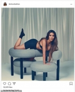 Kim Kardashian poses atop a chic tete-a-tete chair in pieces from her newly released SKIMS