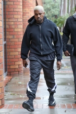Kanye West braves stormy Los Angeles weather to face