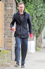 Tom Hiddleston cuts a scruffy figure in hoodie and holey tracksuit