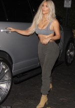 Kardashian looks miserable as she goes out in just a bra... amid reports she's struggling
