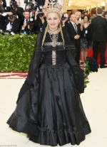 Madonna is a Gothic queen covered in crosses and a net veil at Catholic themed Met Gala