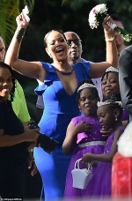 Rihanna flaunts her ample cleavage while playing the ultimate bridesmaid