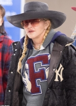 Madonna rocks dapper hat and blonde pigtails as she heads through JFK